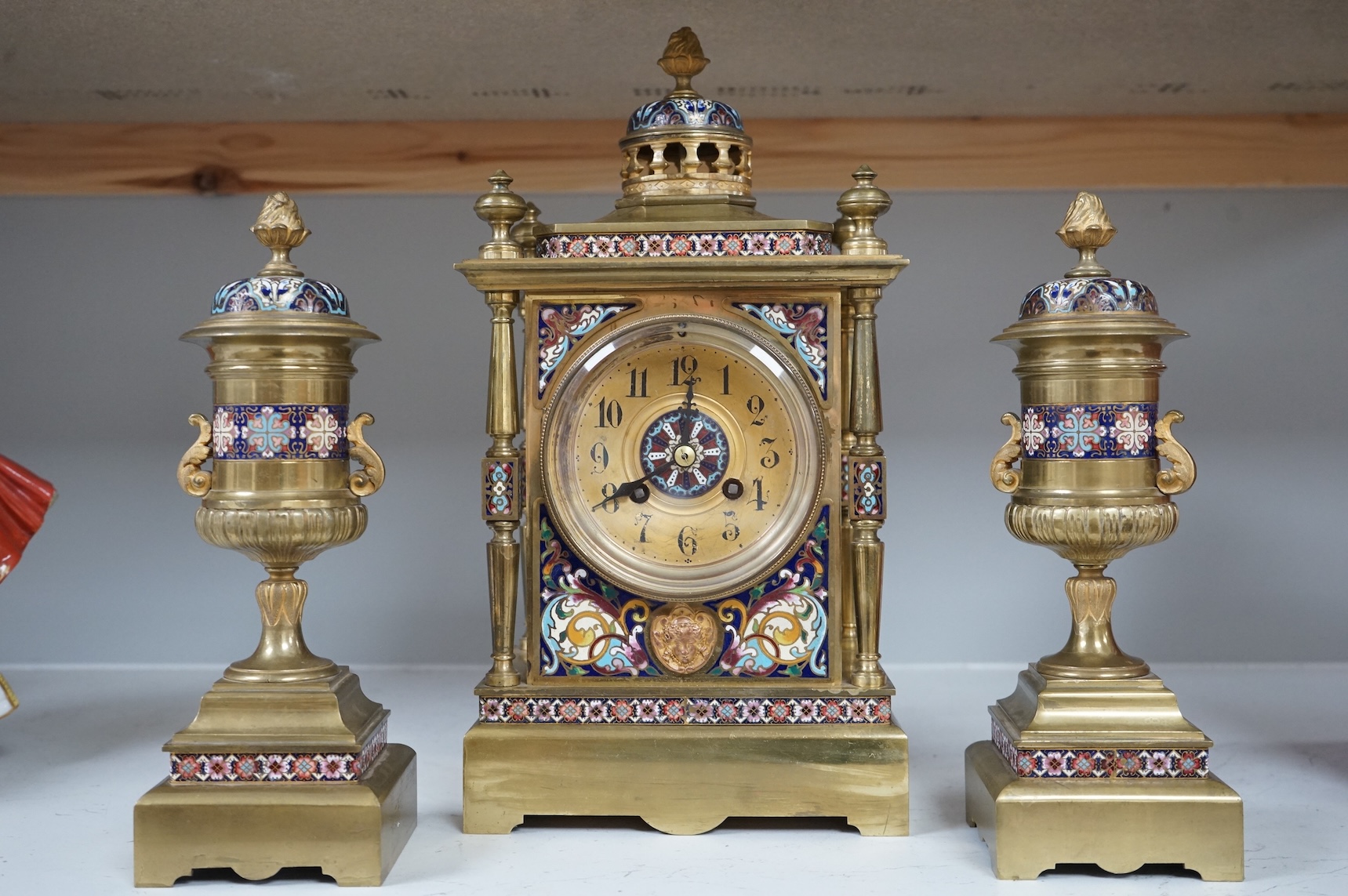 A large early 20th century French brass and champlevé enamel clock garniture, 35cm high
